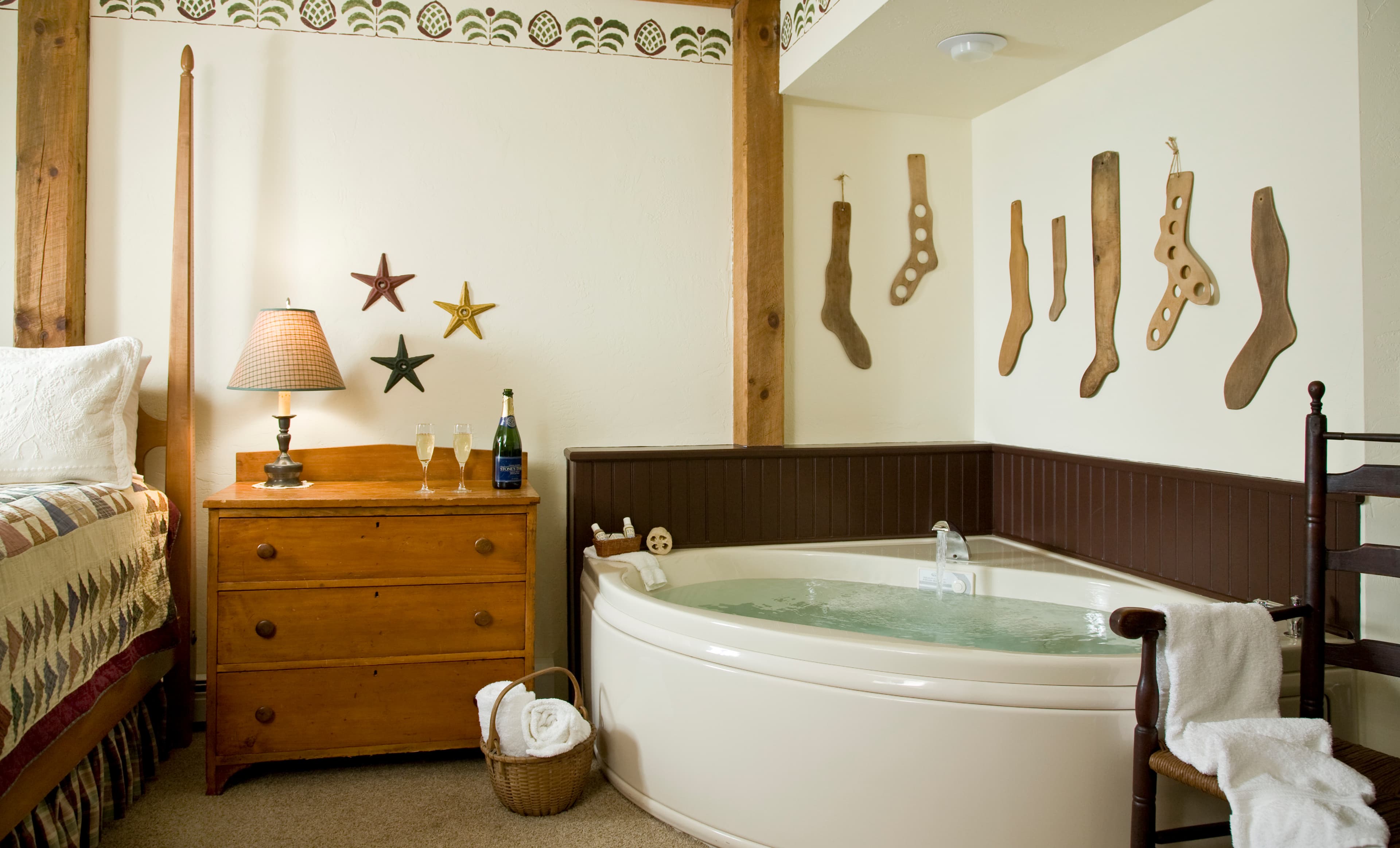 A large white whirlpool tub set against a dark wood wainscoted wall, decorated with several vintage wooden sock stretchers hanging above it.