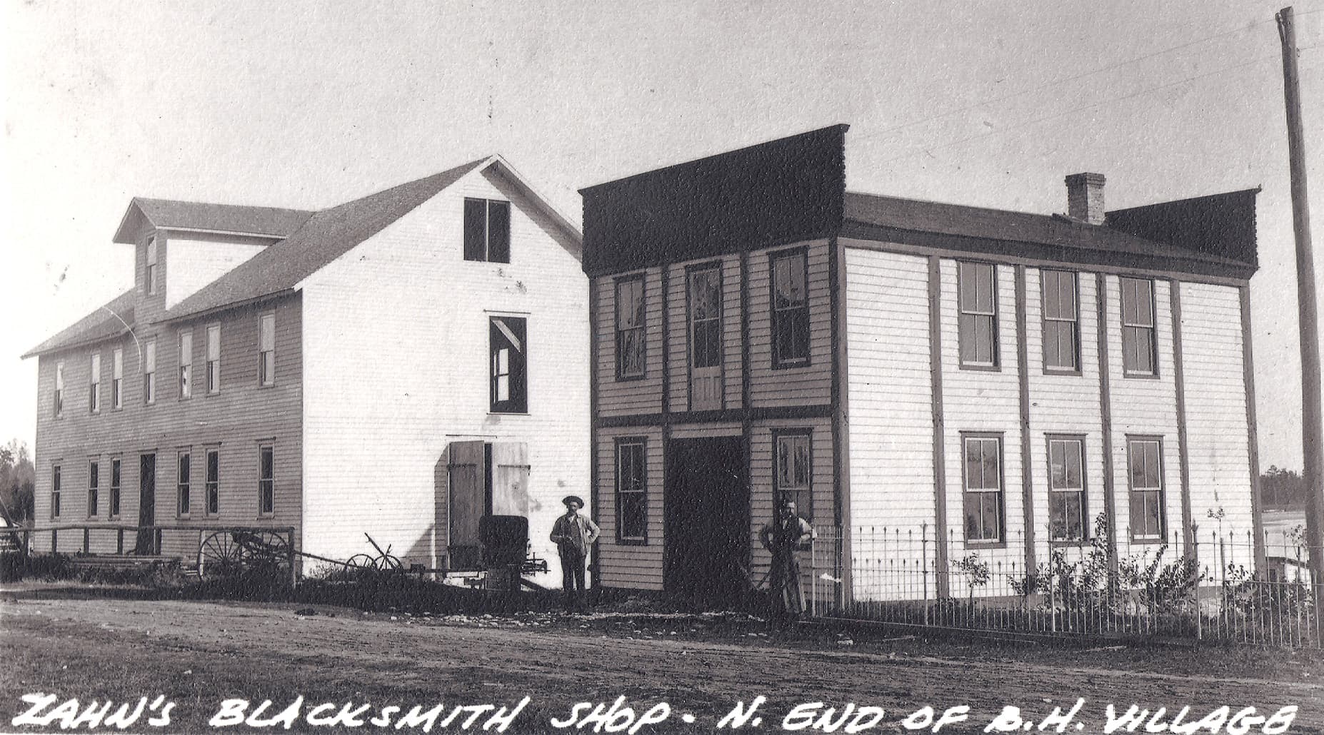 Historic blacksmith shop and adjacent building in a rural village setting.