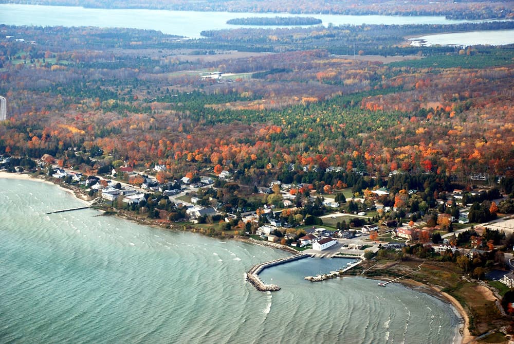 Aerial view of a lakeside community surrounded by autumn foliage.