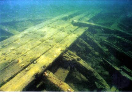 Underwater view of weathered wooden planks and debris.